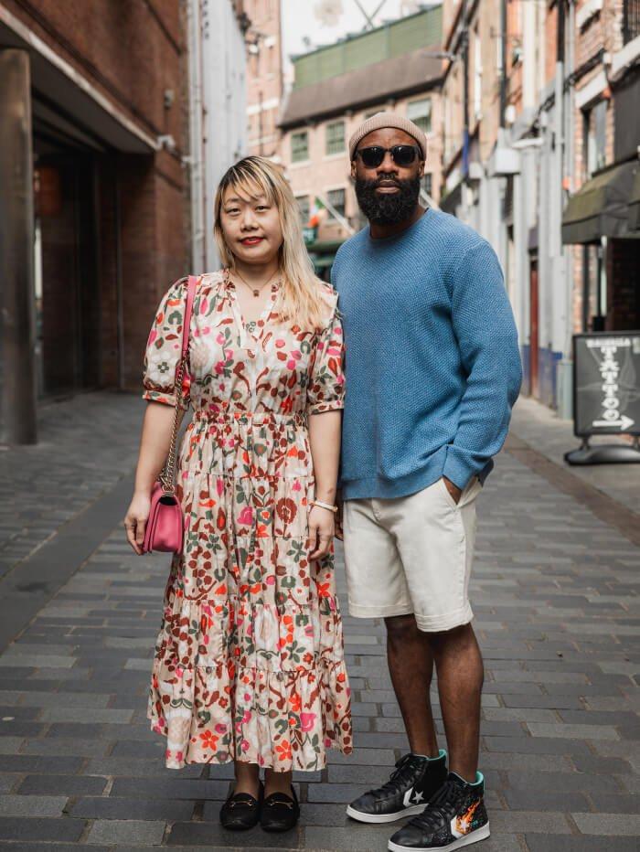 woman in floral maxi dress and man in chino shorts in cute street in Liverpool